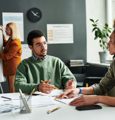 Young confident Middle Eastern male student talking to other learner