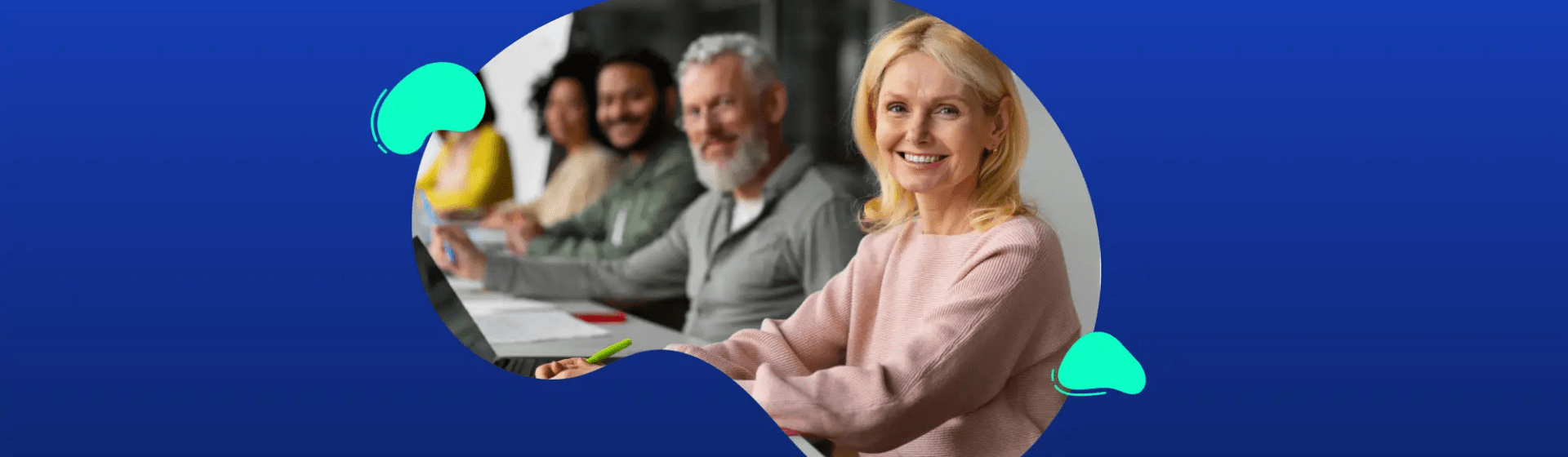 A group of adults sits at a table, smiling and looking forward, with a blue background and abstract shapes framing the photo—perfect for representing Universities, Colleges, and Schools.